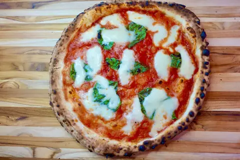 A wood-fired margherita on a board